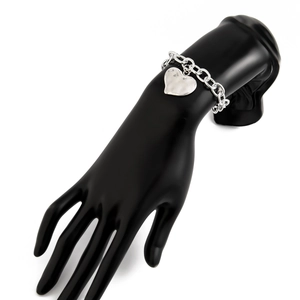 Dettaglio del bracciale con ciondolo a cuore argento con anelli spessi su modello