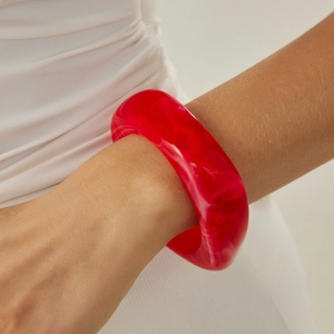 Macro shot of chunky red translucent resin bracelet featuring a bold geometric design
