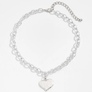 Collana a catena argentata stile Ins con pendente a cuore minimalista su sfondo bianco