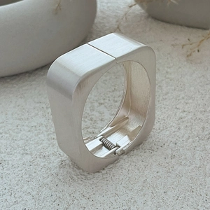 Minimalist silver square spring bracelet with matte brushed finish and geometric design