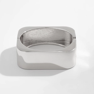 Modern silver wide geometric spring bangle with a mirror finish and rectangular design