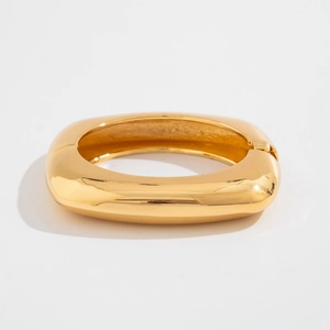 Macro detail of the polished gold square spring bracelet with its hinge buckle mechanism