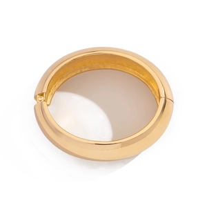 Detailed view of a wide gold metallic hinge bracelet with a high-polished mirror finish