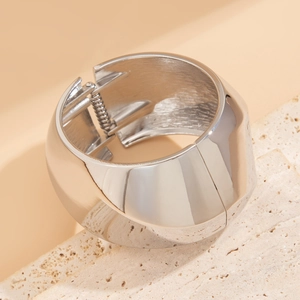 Detailed close-up of a silver wide hinge bracelet with high-polish finish on stone base