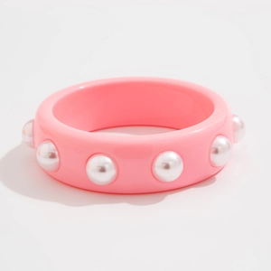 Detalle de brazalete ancho de resina rosa con purpurina y perlas blancas de imitación