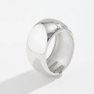 Macro detail of the hinged spring clasp inside a wide polished silver bangle