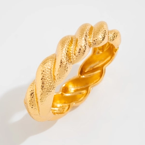 Macro shot of gold twisted rope bangle with detailed hammered texture and matte finish