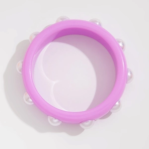 Vista detallada de una pulsera de resina púrpura brillante con perlas de imitación