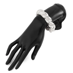 Close-up of chunky silver twisted bracelet with textured metal finish on a hand stand