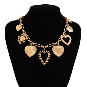 Detail of gold tone multi-heart pendants with textured patterns on a choker necklace