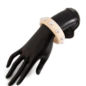 Vista detallada del brazalete de resina beige con adornos de perlas blancas de imitación