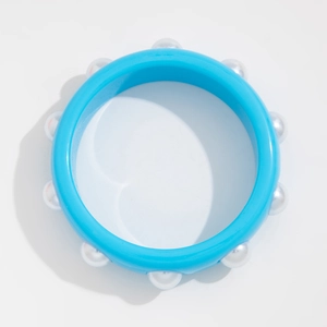 Primer plano de pulsera azul cielo con perlas de imitación y acabado de resina brillante