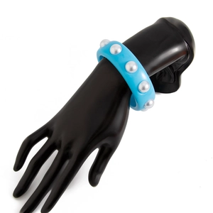 Primer plano del brazalete ancho de resina azul cielo con detalles de perlas plateadas