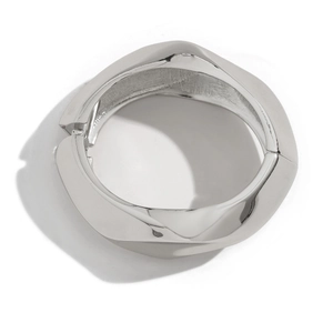 Irregular irregular silver bangle with geometric spring hinge closure on white background