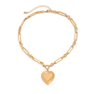 Macro detail of gold-plated heart pendant with radial grooves and paperclip chain links