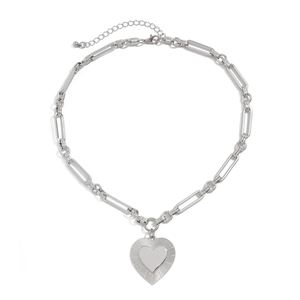 Detailed macro of textured heart pendant necklace with industrial silver link chain