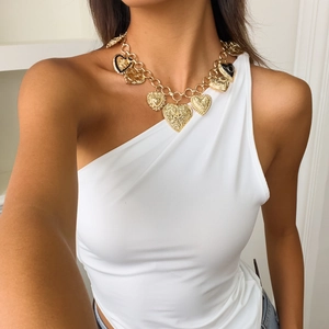 Detailed view of chunky gold chain necklace with heart pendants on a female model