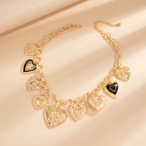 Detail of gold heart charms on chunky chain necklace with floral relief patterns