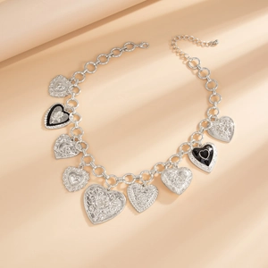 Macro view of silver-toned heart charms with rose texture and baroque metal patterns