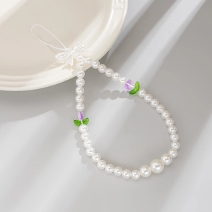 Detail of beaded phone strap featuring white faux pearls, purple tulips, and a bow charm