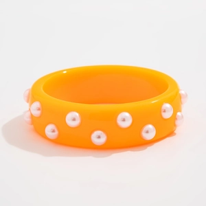 Primer plano de brazalete ancho de acrílico naranja con perlas de imitación blancas