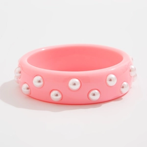 Detalle de brazalete de resina rosa con dos filas de perlas blancas brillantes y lisas