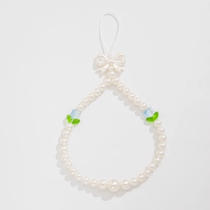 Detail of beaded phone strap with white pearls, cream bow, and colorful flower accents