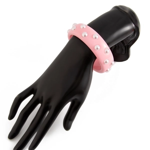 Detalle de brazalete de resina rosa con perlas artificiales en modelo negro