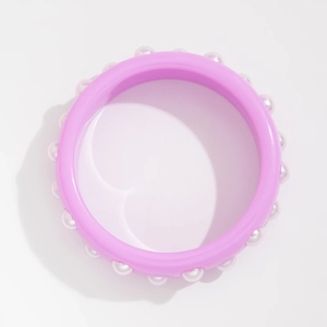 Detalle de brazalete ancho de resina lavanda con perlas blancas incrustadas