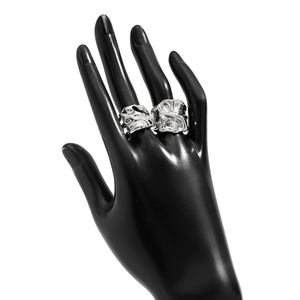 Detail von silbernen Liquid-Lava-Ringen mit Faltenstruktur auf schwarzem Handmodell