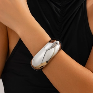 Polished silver metal wide bangle featuring a high-gloss finish and minimalist aesthetic