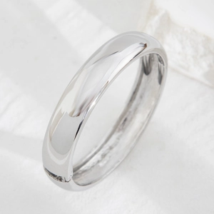 Macro shot of polished silver-colored dome ring with a mirror finish on stone background