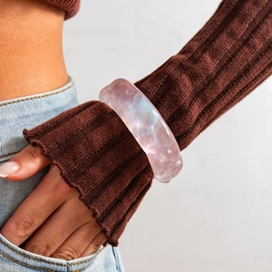 Detalle de brazalete ancho de resina rosa con purpurina iridiscente y brillo perlado