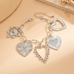 Detailed close-up of retro silver chain bracelet with five unique textured heart charms