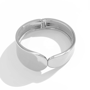 Detalle del brazalete ancho plateado con bisagra de resorte y acabado de espejo