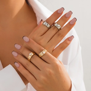 Detailed view of four lava texture rings in gold and silver with inlaid white pearls