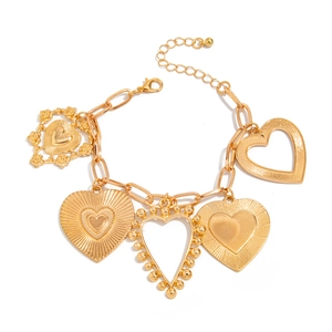 Detail of gold heart pendant bracelet with multi-style charms and chunky curb chain