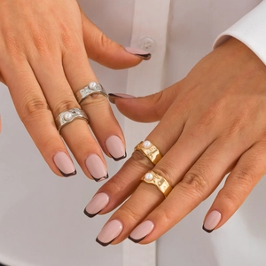 Close-up of liquid lava texture rings with baroque pearls in gold and silver finish