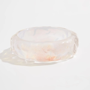Primer plano de brazalete holográfico translúcido con textura ondulada y brillo perlado
