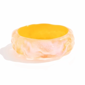 Primer plano de brazalete ancho de resina amarilla con ondas y acabado de nácar