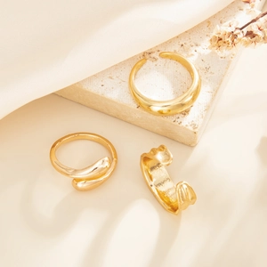 Detailed view of minimalist gold drip ring and irregular cuff on a stone tray