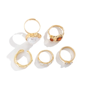 Five-piece gold ring set featuring faux pearl, orange stones, and wavy metal textures