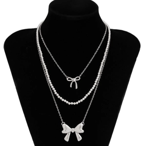 Three-layer silver beaded necklace with hollow and solid butterfly pendants on stand