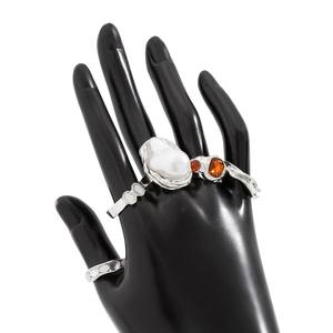Detail of silver lava flower ring with baroque pearl and amber gemstone on hand
