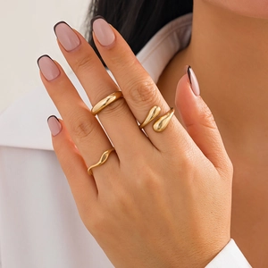 Ensemble de trois bagues dorées minimalistes avec finitions polies portées par un mannequin