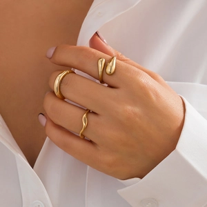 Three-piece gold ring set featuring wide curved band, droplet shape, and wavy texture