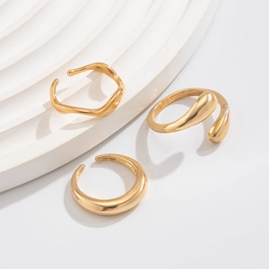 Minimalist gold geometric ring set featuring wavy and irregular shapes on white display