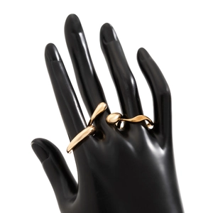 Détail d'une bague goutte d'eau dorée polie sur une main de mannequin noire