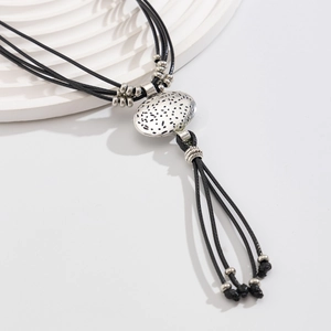 Detailopname van vintage ovale metalen hanger met zilveren textuur en kwastjes-afwerking