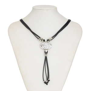 Close-up of bohemian silver oval pendant with textured finish on multi-strand black cord
